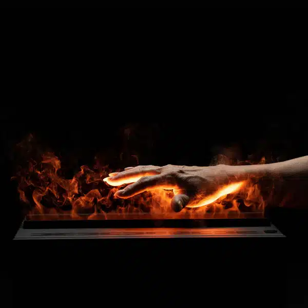 A hand hovers just above orange flames rising from a rectangular black surface, set against a black background.